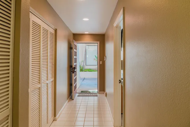 a view of a hallway with a livingroom and a bathroom with sink