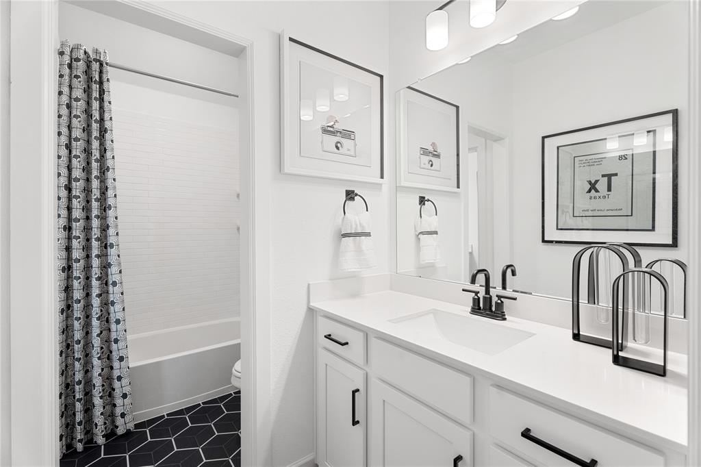 426 Plains Place Fate, TX 75087 - Photo 21 of 24 a bathroom with a sink a mirror a vanity and shower