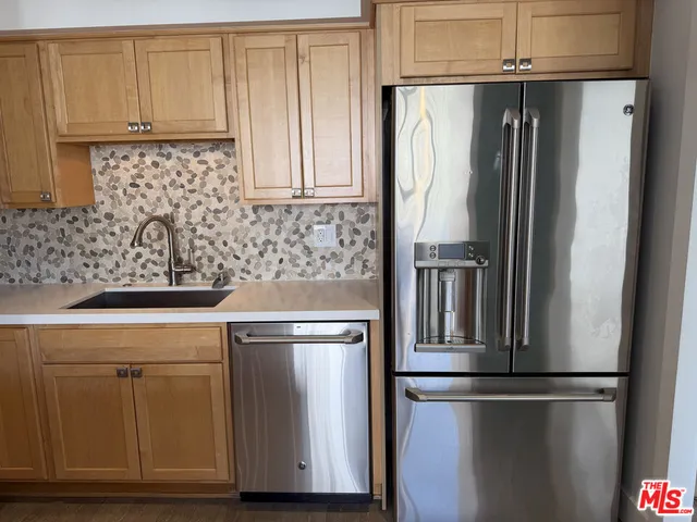 a kitchen with stainless steel appliances granite countertop a refrigerator and a sink