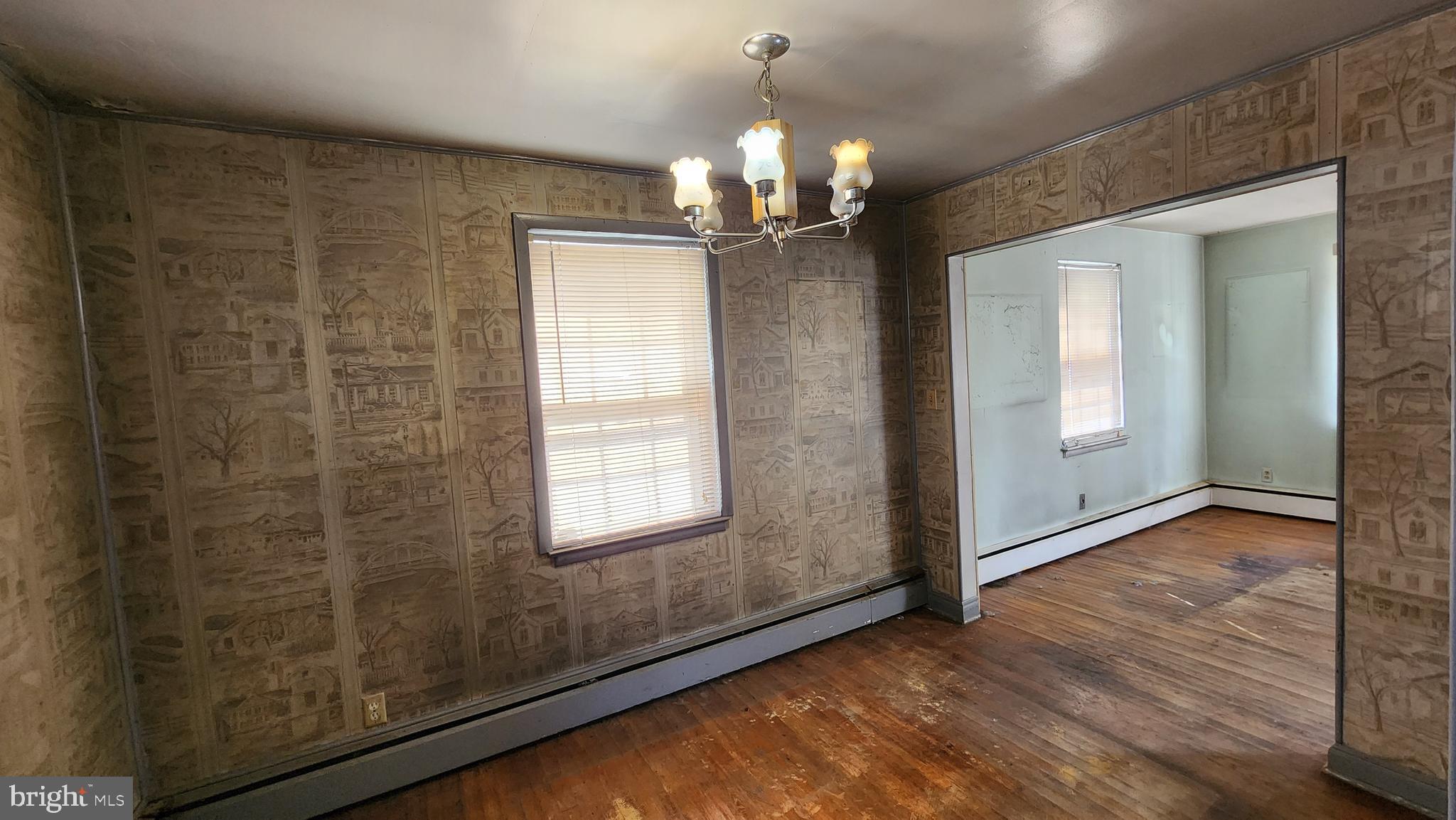 936 Olmstead Road Baltimore, MD 21208 - Photo 10 of 24 an empty room with wooden floor chandelier and windows