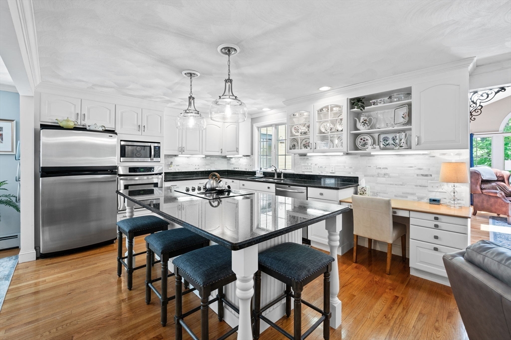 9 Sagamore Road Ipswich, MA 01938 - Photo 14 of 42 a kitchen with kitchen island a dining table chairs stainless steel appliances and cabinets