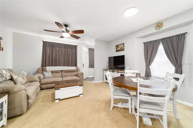 a living room with furniture a flat screen tv and a window