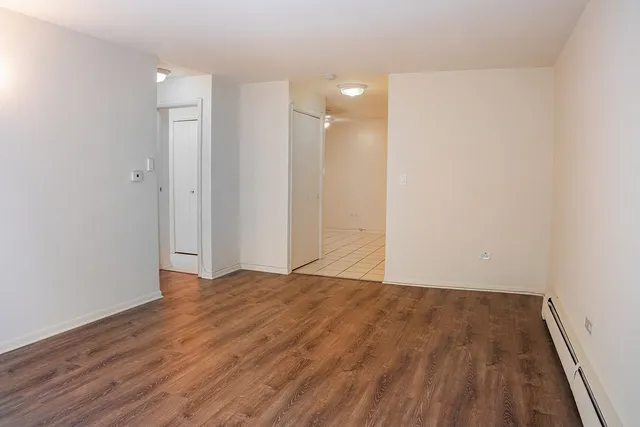a view of empty room with wooden floor