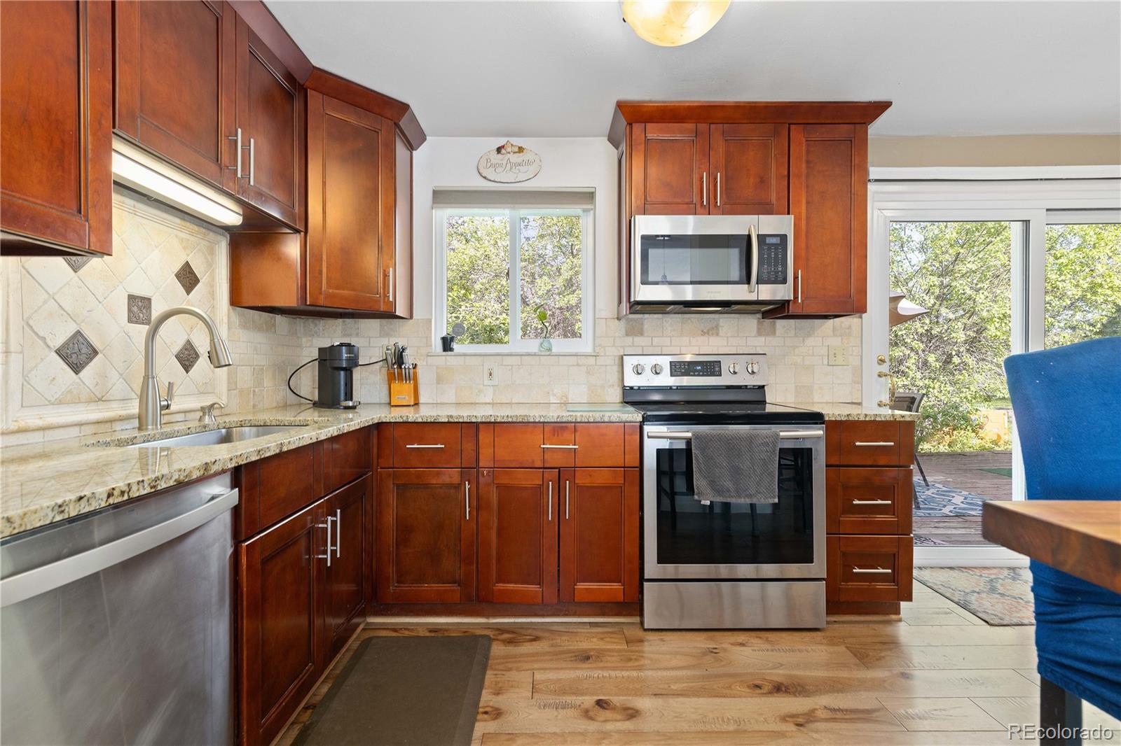 4374 East Peakview Circle Centennial, CO 80121 - Photo 11 of 45 a kitchen with stainless steel appliances granite countertop a stove a sink dishwasher and a microwave oven with cabinets