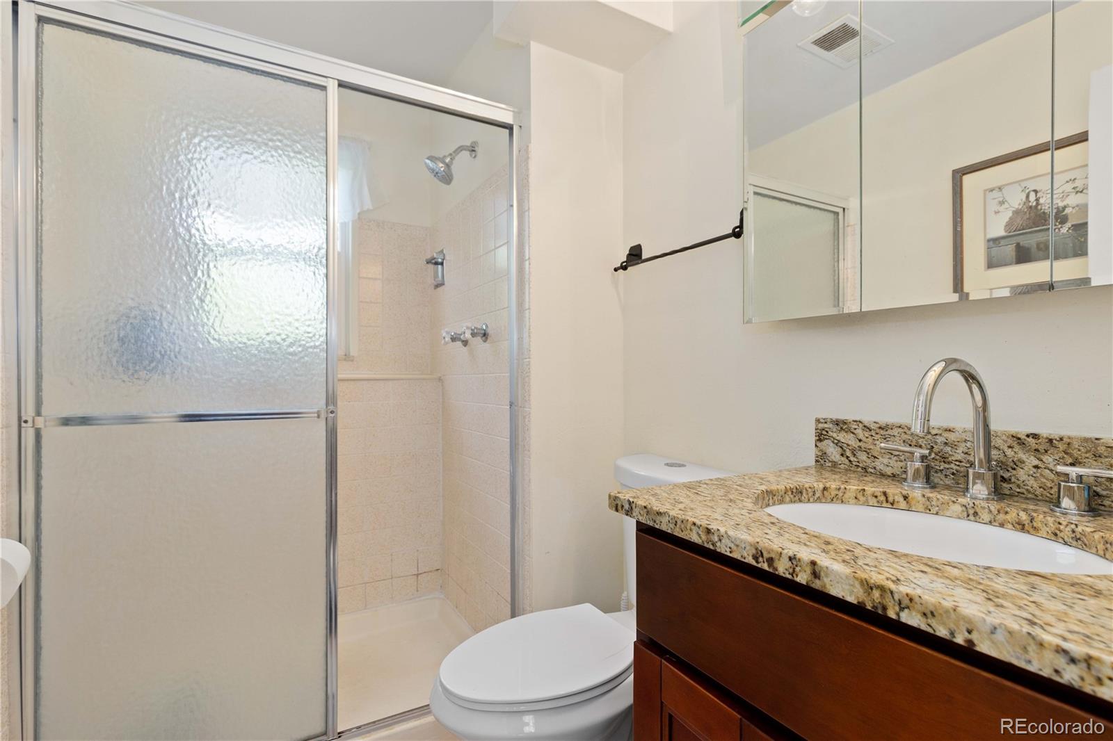 4374 East Peakview Circle Centennial, CO 80121 - Photo 22 of 45 a bathroom with a granite countertop sink toilet and shower