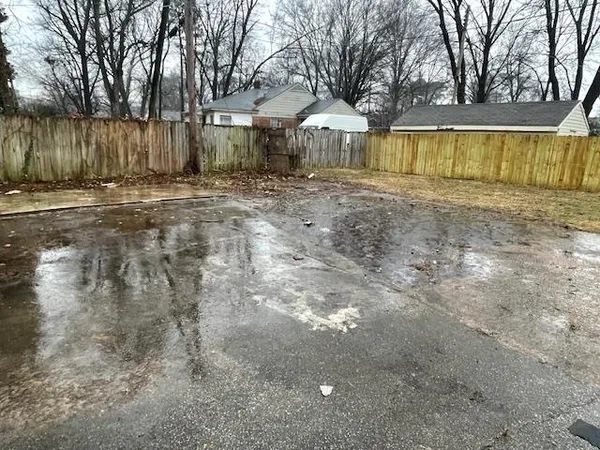 a view of large yard with wooden fence