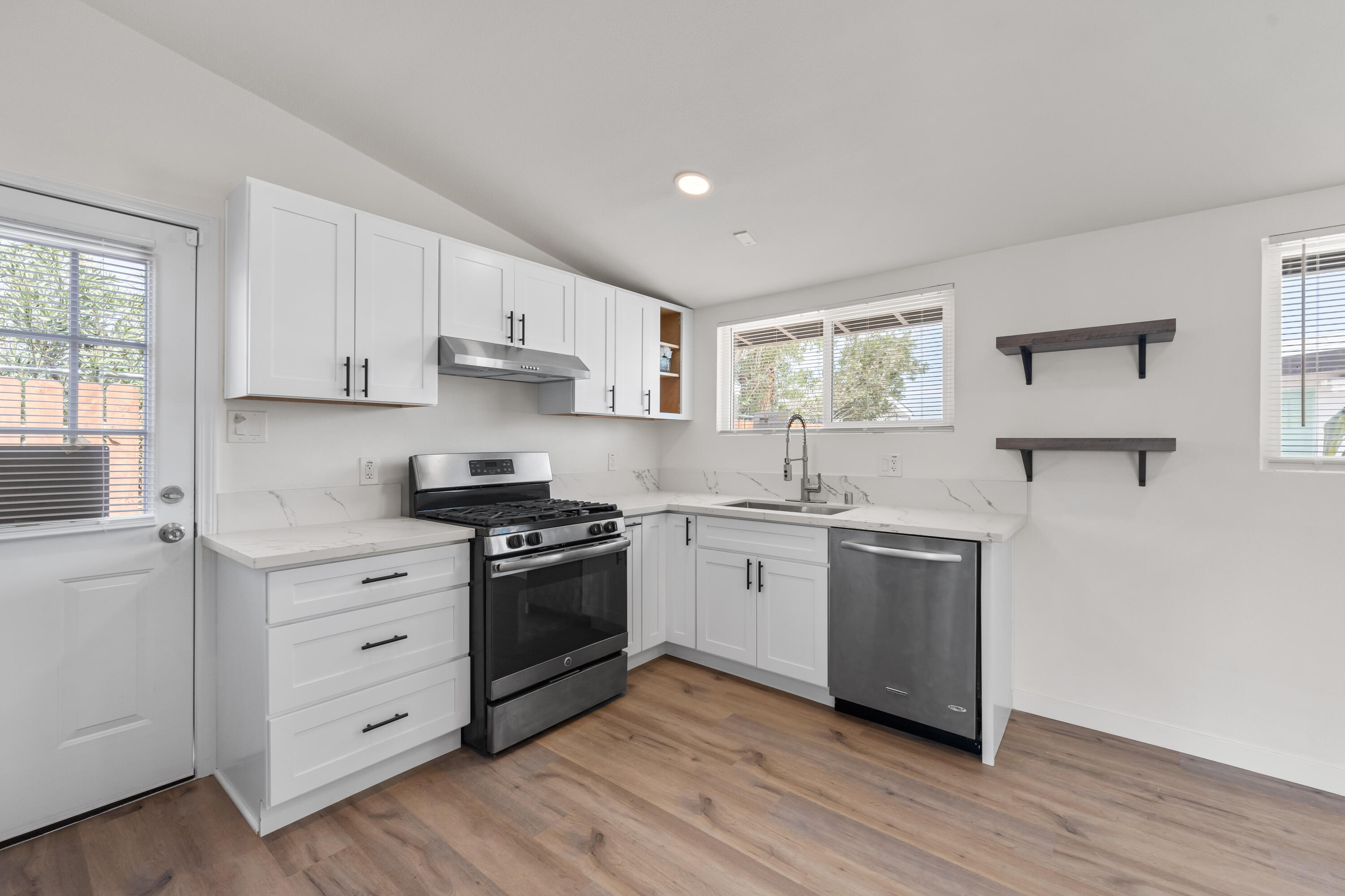15593 M Street Mojave, CA 93501 - Photo 18 of 53 a kitchen with cabinets appliances wooden floor and a window
