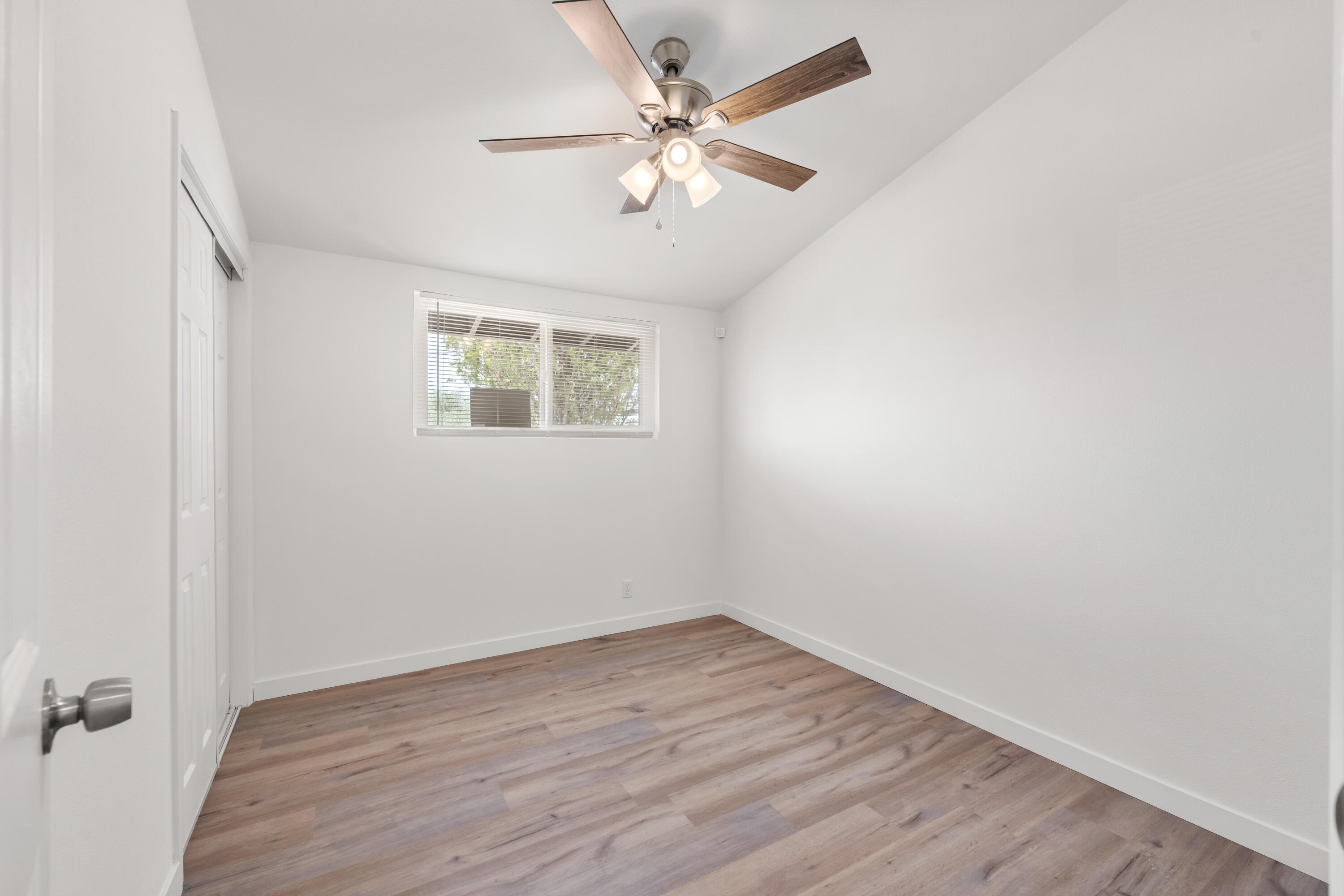 15593 M Street Mojave, CA 93501 - Photo 29 of 53 an empty room with wooden floor chandelier fan and windows
