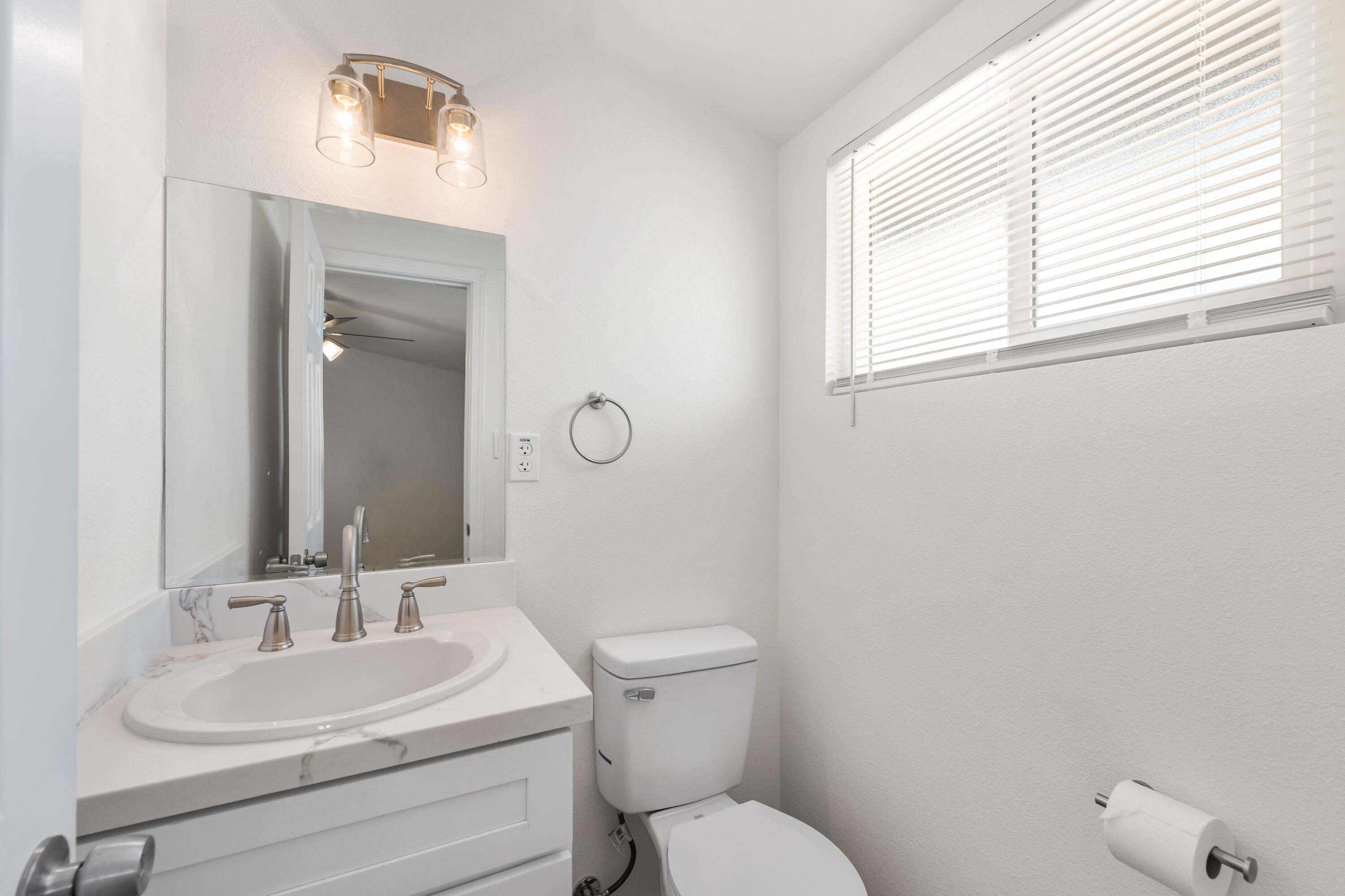 15593 M Street Mojave, CA 93501 - Photo 38 of 53 a bathroom with a toilet a sink a mirror and a window