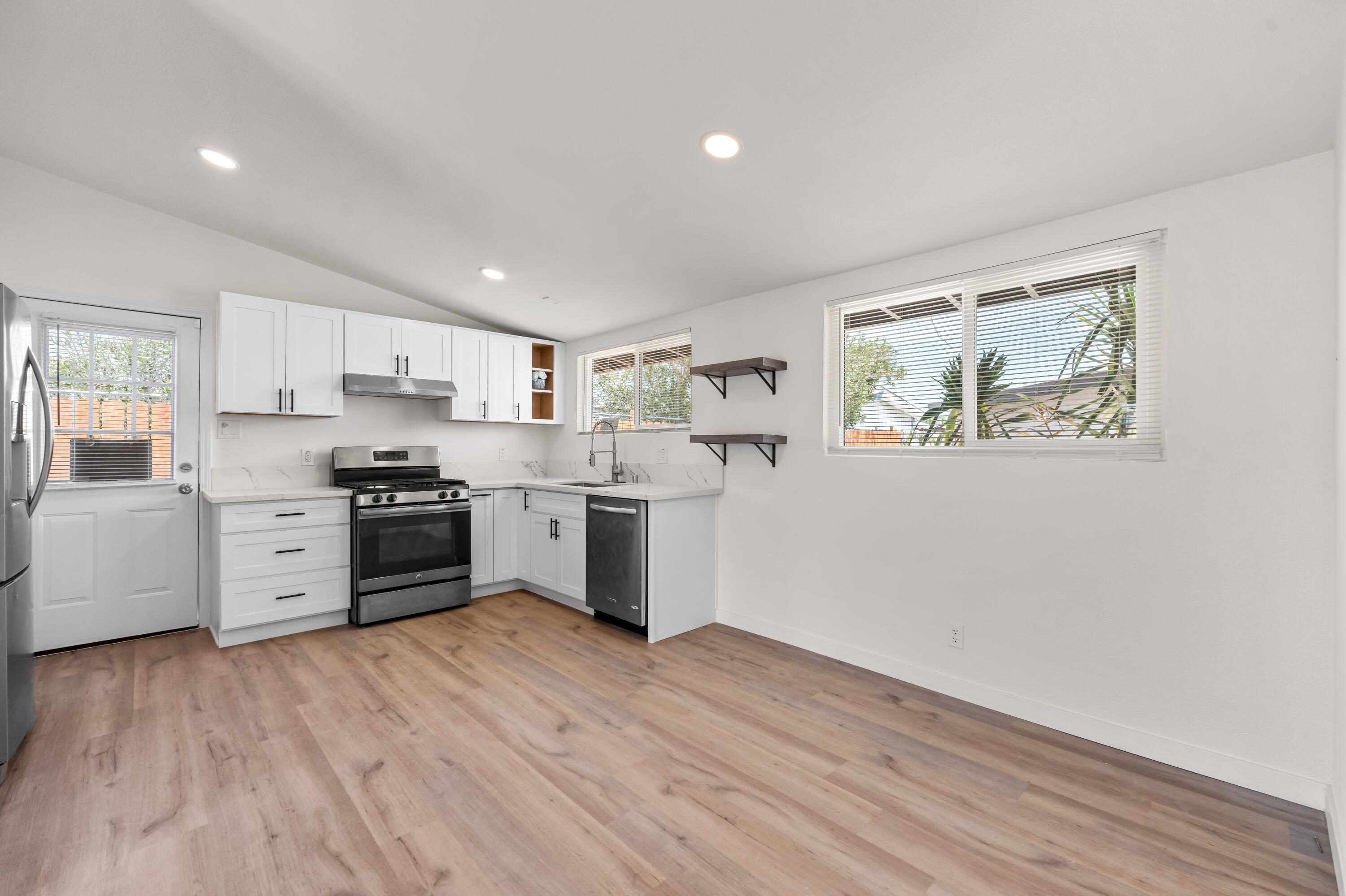 15593 M Street Mojave, CA 93501 - Photo 8 of 53 a kitchen with stainless steel appliances a refrigerator and a stove top oven
