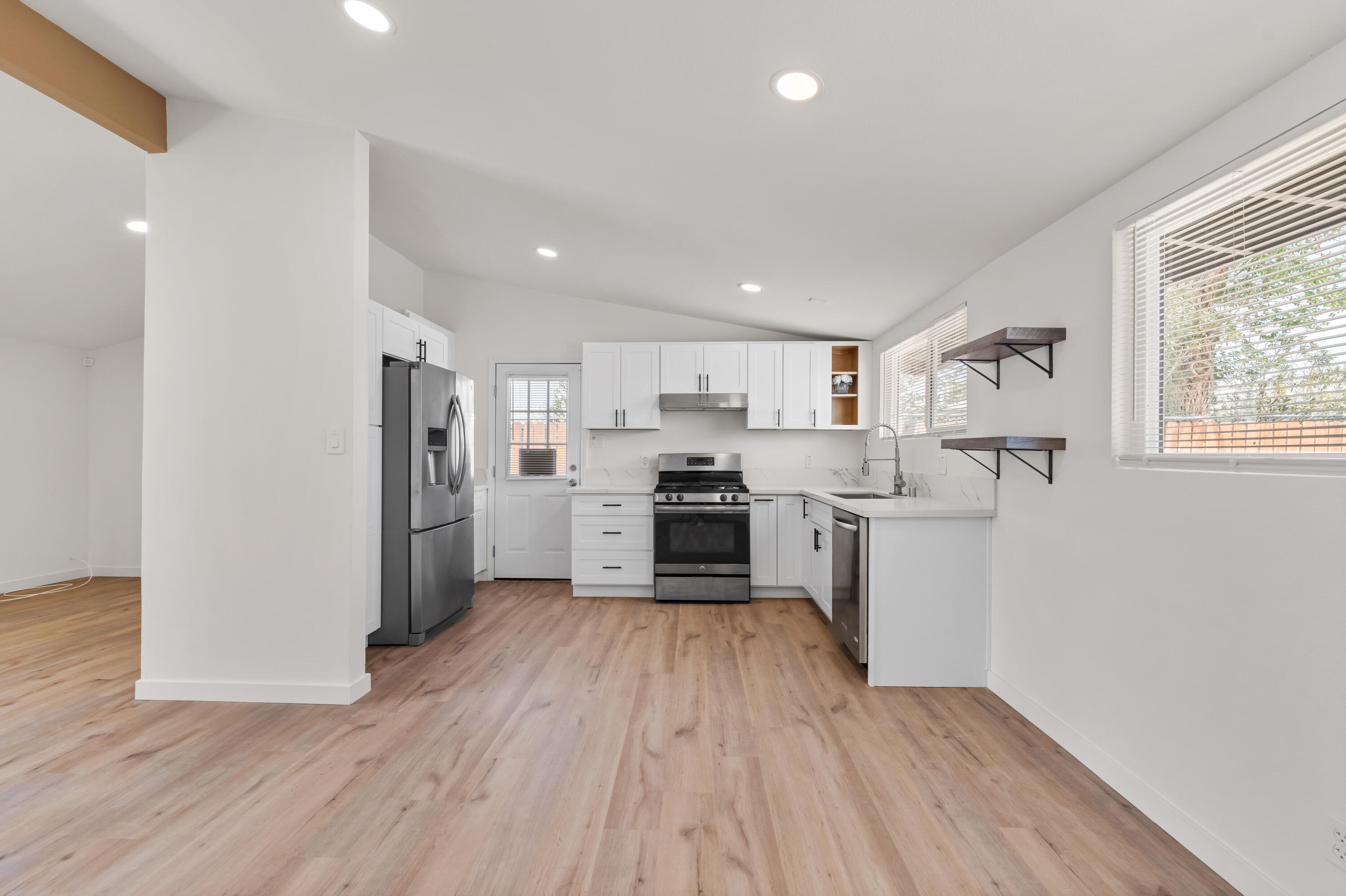 15593 M Street Mojave, CA 93501 - Photo 10 of 53 a kitchen with white cabinets and stainless steel appliances
