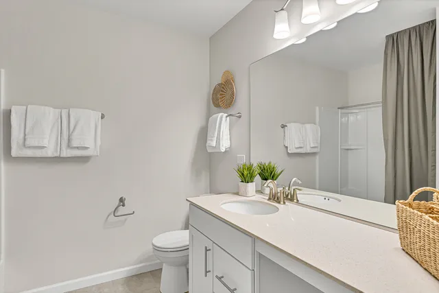 a bathroom with a sink vanity granite and toilet