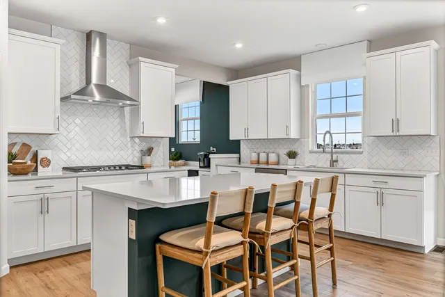 a kitchen with a dining table chairs cabinets and stainless steel appliances