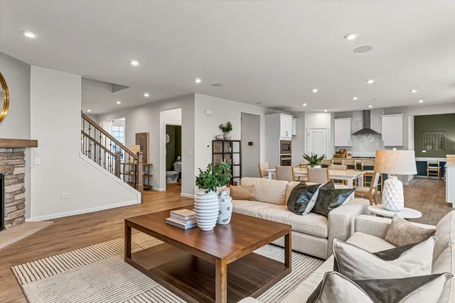 a living room with furniture kitchen view and a wooden floor
