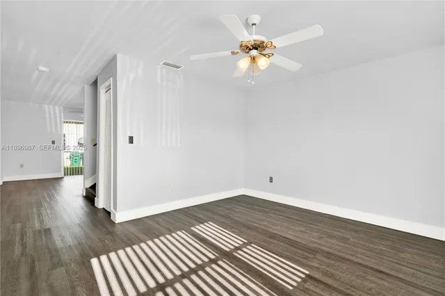 a view of an empty room with wooden floor