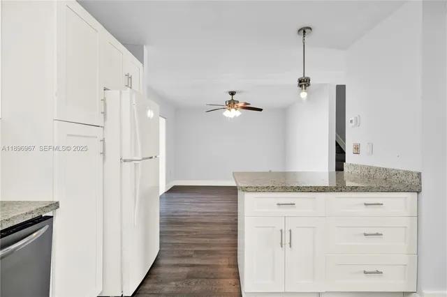a kitchen with a granite countertop sink and a refrigerator