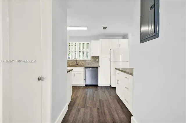 a kitchen with cabinets wooden floor and stainless steel appliances
