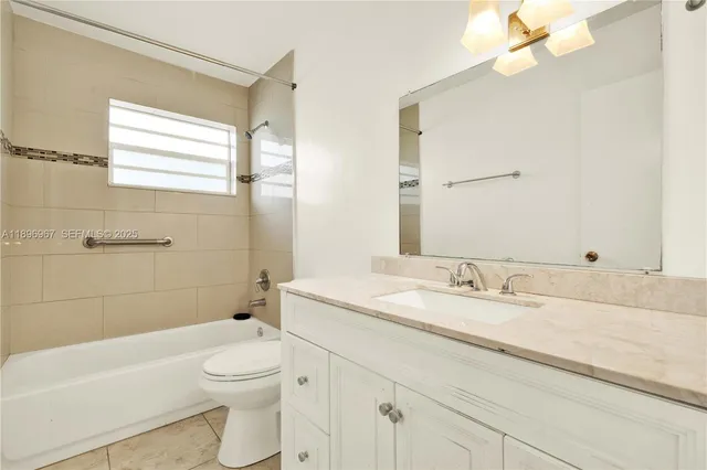 a bathroom with a granite countertop sink a toilet and a bathtub