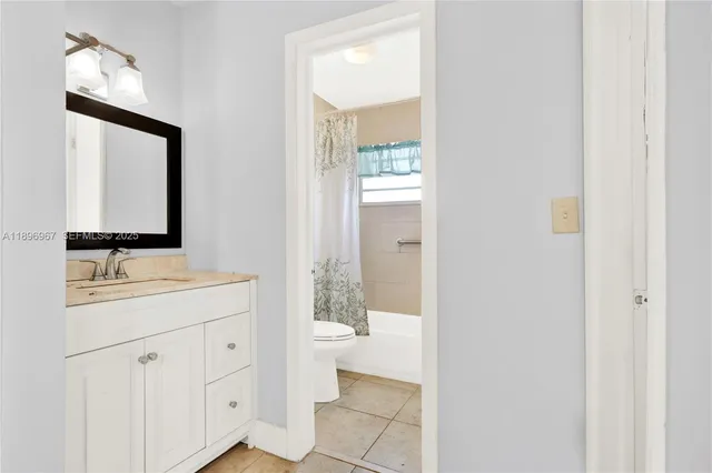 a bathroom with a toilet a sink a mirror and vanity