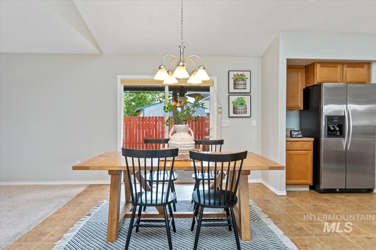 80 Cobblestone Court Middleton, ID 83644 - Photo 11 of 48 Dining area featuring a sliding glass door for outdoor access, a chandelier light fixture, and wood-finish flooring