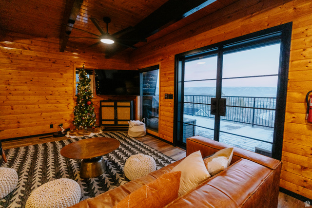 1413 Basel Drive Midway, UT 84049 - Photo 16 of 137 Living room with wood walls, wood finished floors, a ceiling fan, a wood ceiling with exposed beams, and a fireplace