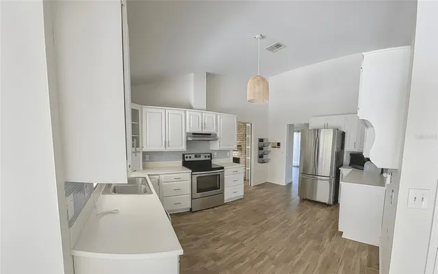 a kitchen with stainless steel appliances a refrigerator and a stove top oven