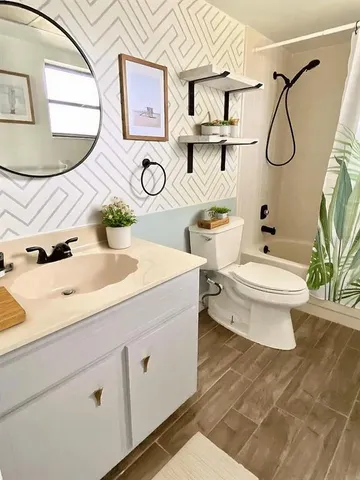 a bathroom with a granite countertop sink a toilet and mirror