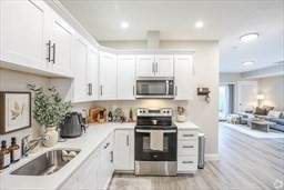 31 Ridge Street, Unit 304 Worcester, MA 01604 - Photo 3 of 3 a kitchen with stainless steel appliances granite countertop a sink a stove and a wooden floors