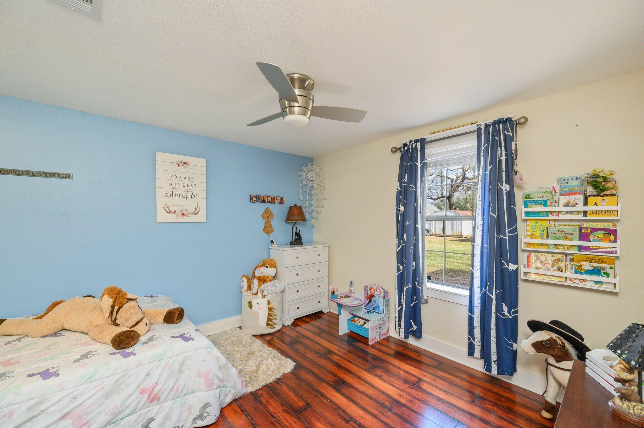 610 Jones Road Crestview, FL 32536 - Photo 28 of 39 a bedroom with a bed wooden floor and window