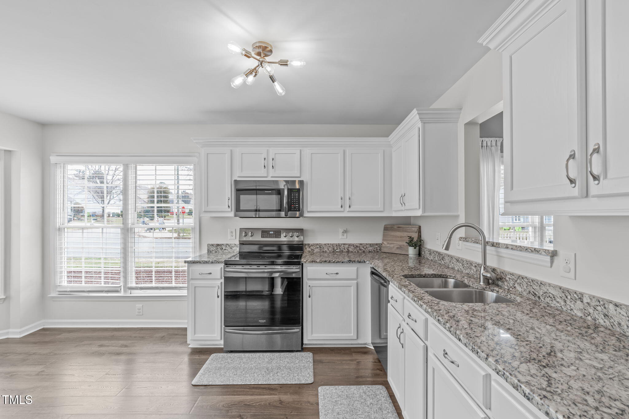 11228 North Radner Way Raleigh, NC 27613 - Photo 7 of 34 a kitchen with stainless steel appliances granite countertop a stove a sink dishwasher and a microwave oven with white cabinets