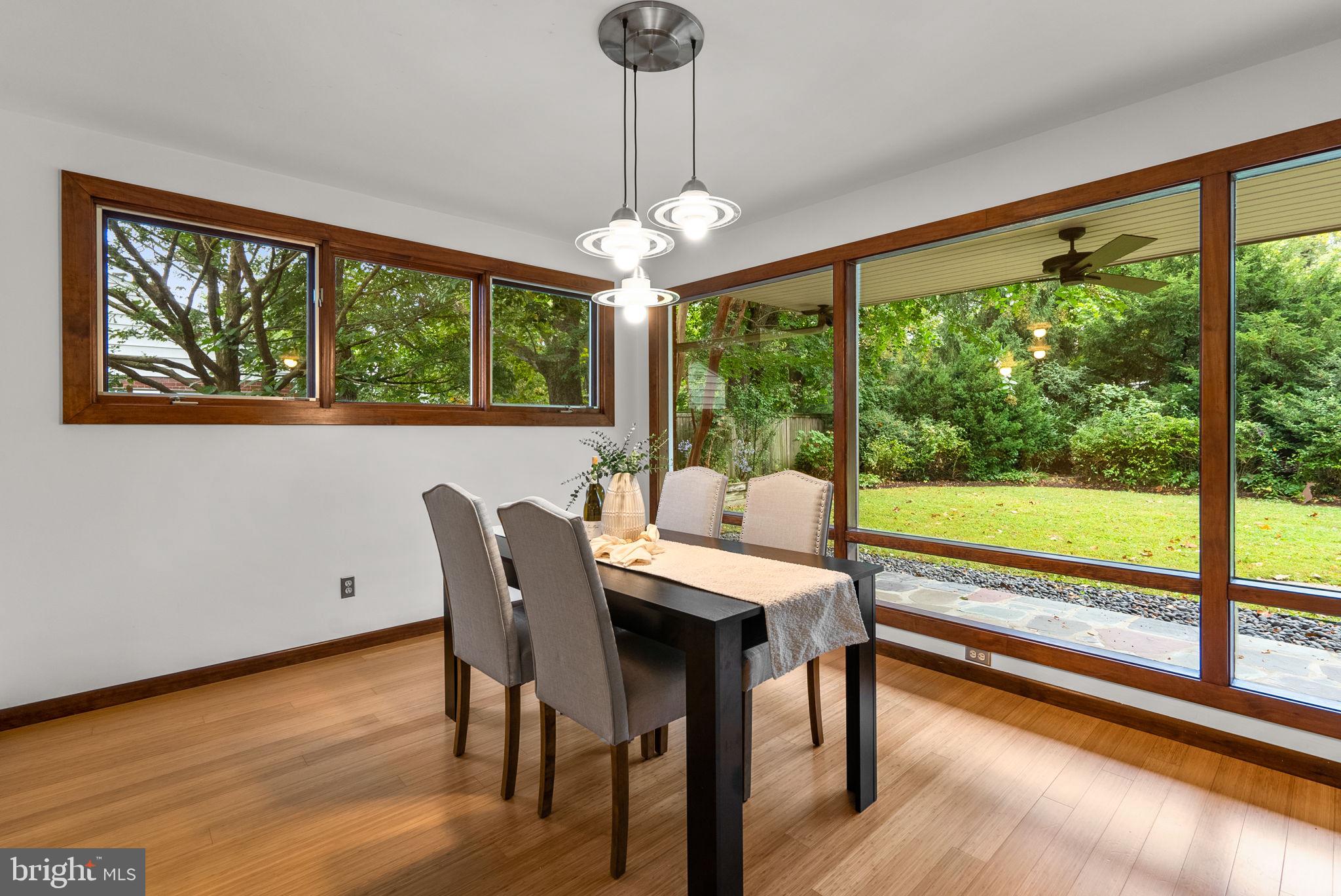9109 Fairview Road Silver Spring, MD 20910 - Photo 11 of 46 a view of a dining room with furniture large windows and wooden floor