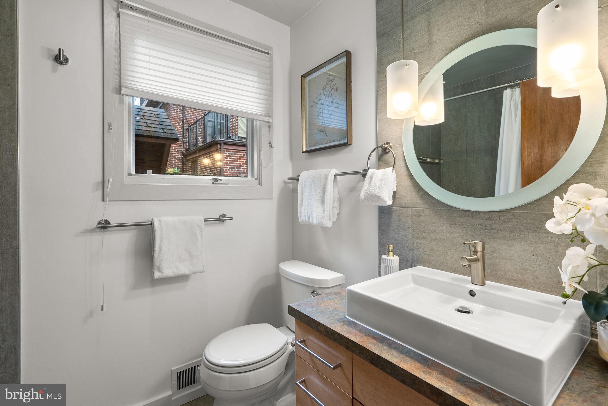 9109 Fairview Road Silver Spring, MD 20910 - Photo 23 of 46 a bathroom with a toilet a sink and mirror