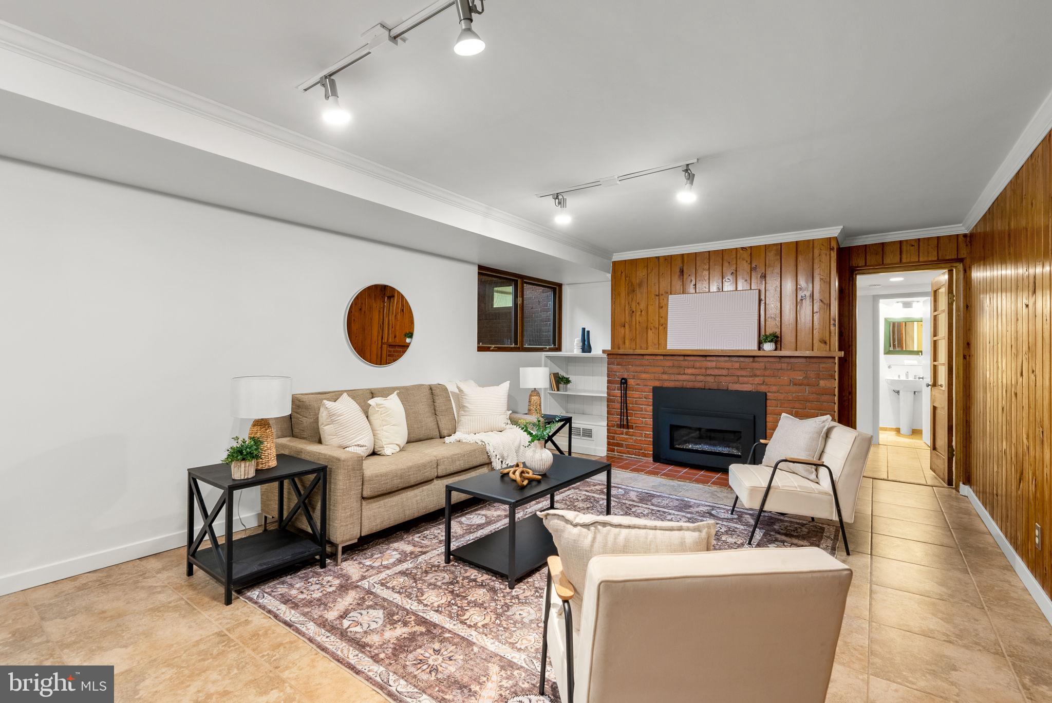 9109 Fairview Road Silver Spring, MD 20910 - Photo 31 of 46 a living room with furniture a fireplace and a flat screen tv