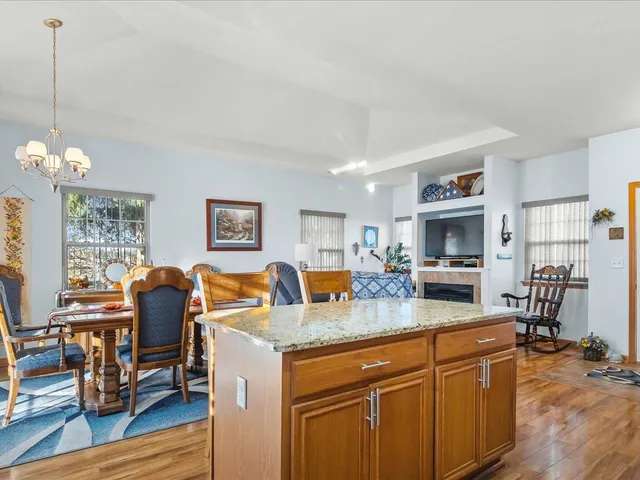 a living room with granite countertop furniture a fireplace and kitchen view