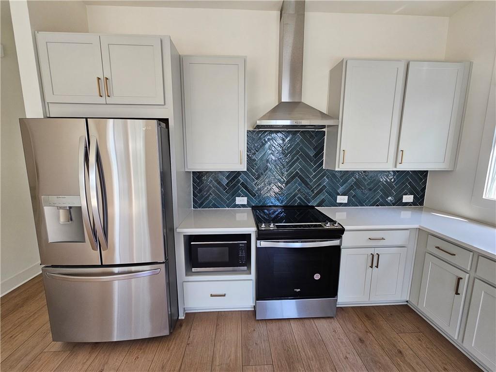 1294 Longreen Terrace Northwest, Unit 2 Atlanta, GA 30318 - Photo 14 of 25 a kitchen with a stove a refrigerator and a hard wood floor