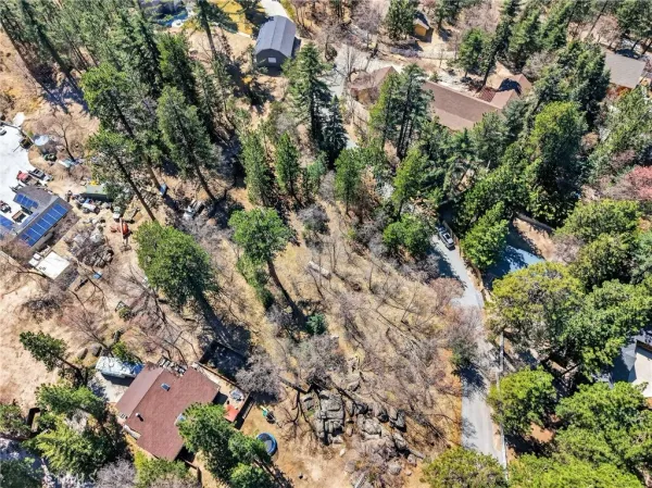 an aerial view of residential house with outdoor space and trees all around