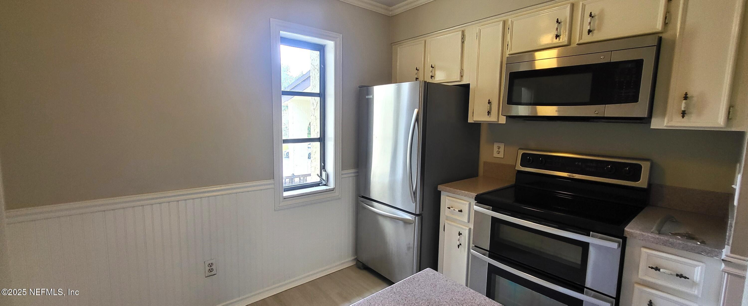 600 Domenico Circle, Unit A12 St. Augustine, FL 32086 - Photo 5 of 11 a kitchen with stainless steel appliances white cabinets and a stove top oven