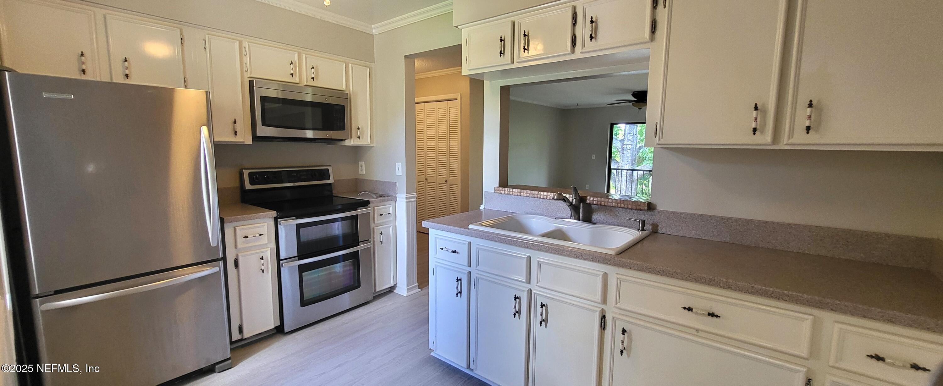 600 Domenico Circle, Unit A12 St. Augustine, FL 32086 - Photo 6 of 11 a kitchen with stainless steel appliances white cabinets and a refrigerator