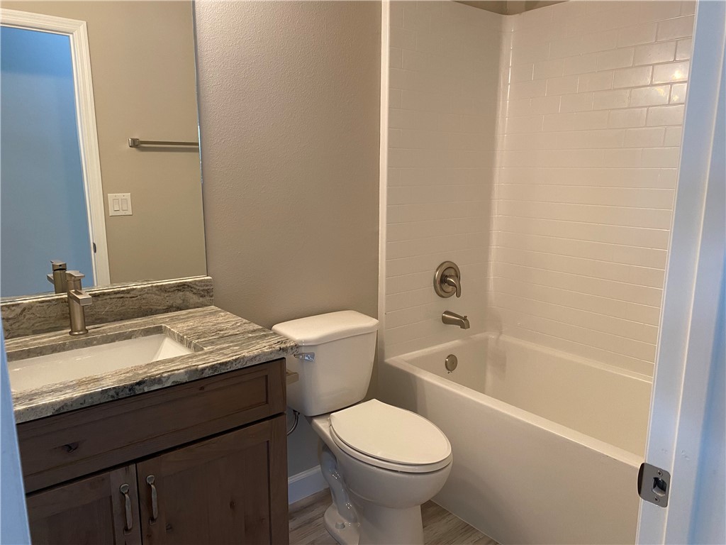 109 Aetna Street, Unit B Sebastian, FL 32958 - Photo 12 of 26 a bathroom with a granite countertop toilet a sink and bathtub