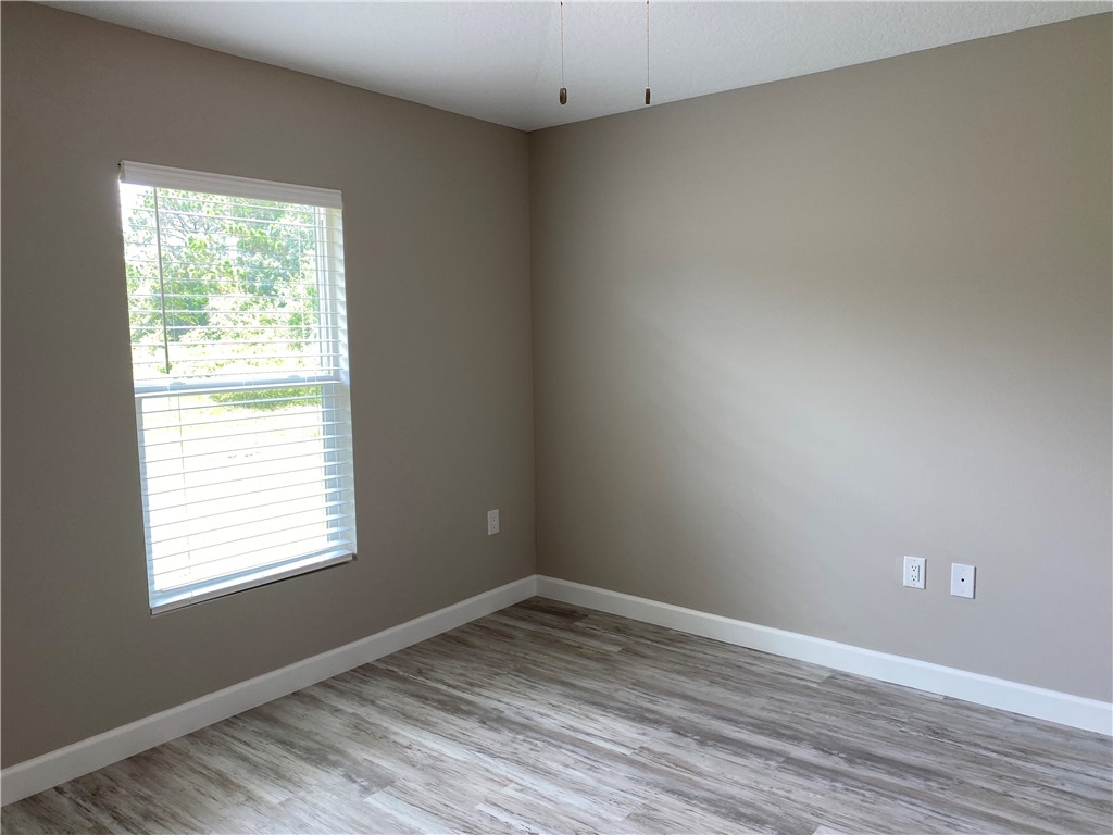 109 Aetna Street, Unit B Sebastian, FL 32958 - Photo 14 of 26 a view of an empty room with wooden floor and a window
