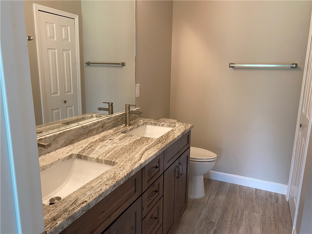 109 Aetna Street, Unit B Sebastian, FL 32958 - Photo 21 of 26 a bathroom with a granite countertop sink a toilet and a mirror