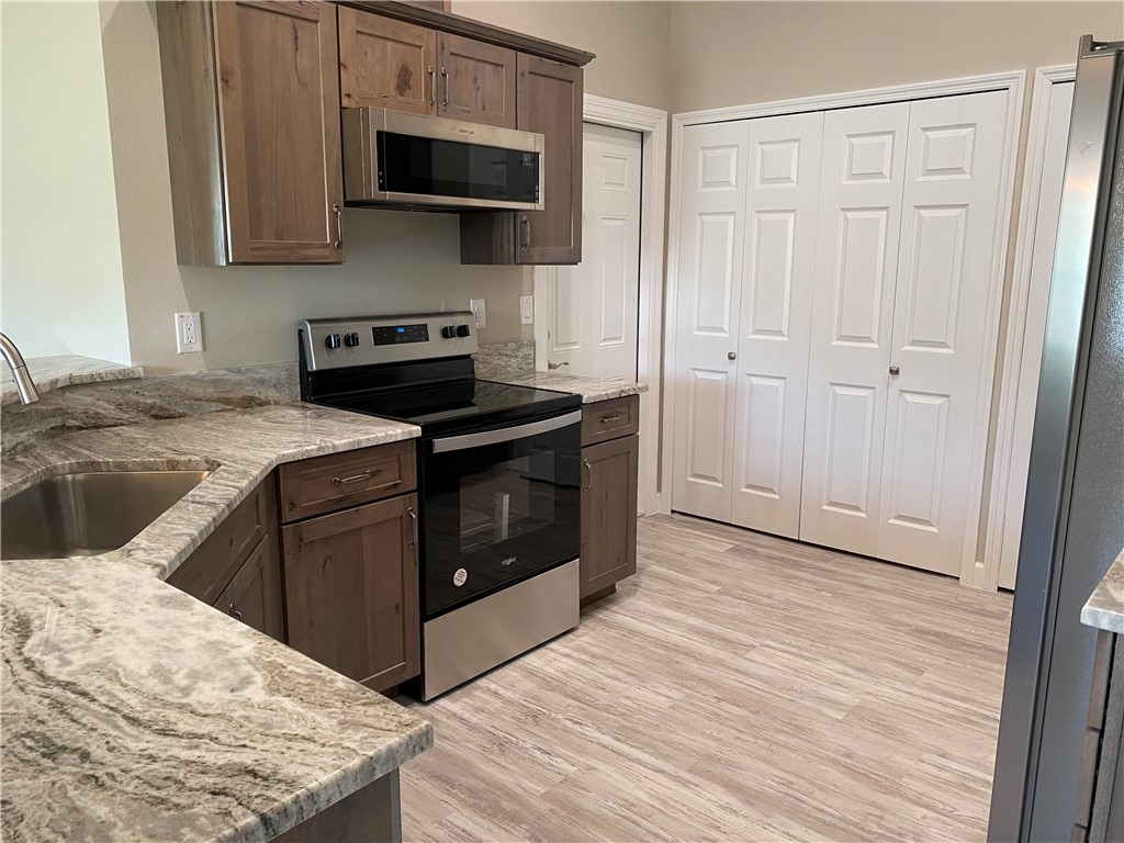 109 Aetna Street, Unit B Sebastian, FL 32958 - Photo 7 of 26 a kitchen with stainless steel appliances granite countertop a stove and a microwave