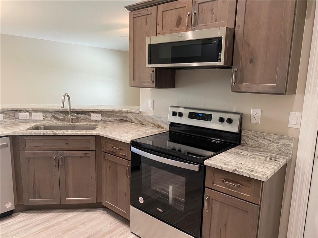109 Aetna Street, Unit B Sebastian, FL 32958 - Photo 8 of 26 a kitchen with stainless steel appliances a stove a microwave a sink and cabinets