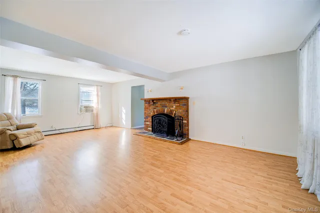 a view of empty room with wooden floor and fireplace