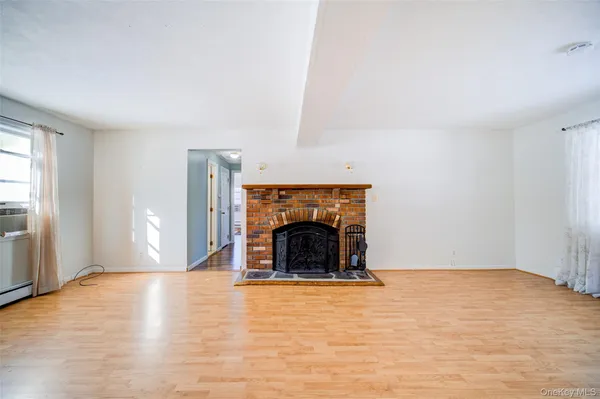 a view of an empty room with window and fireplace