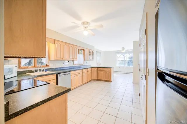 a large white kitchen with a stove a sink and a refrigerator