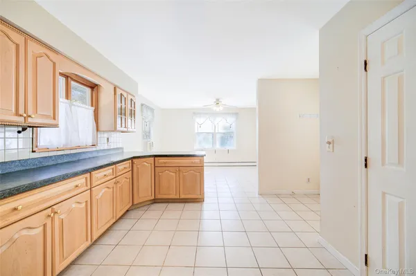 a large white kitchen with sink and cabinets