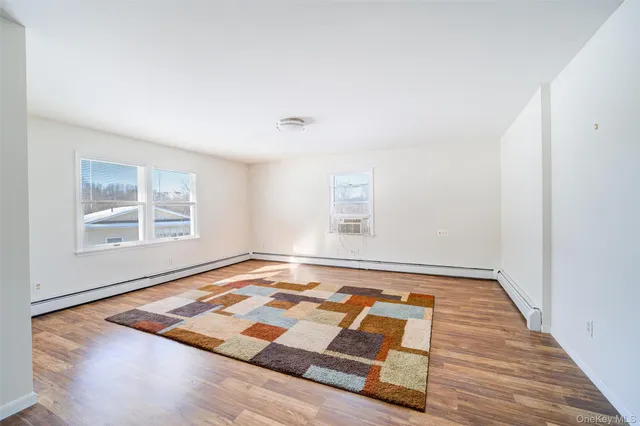 a view of a room with wooden floor and windows