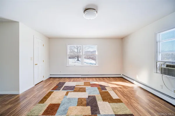 a view of a room with wooden floor and windows