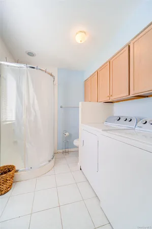 a utility room with cabinets washer and dryer